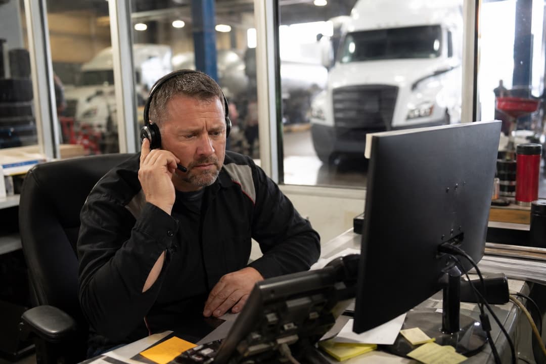 Service manager on a headset in the shop office